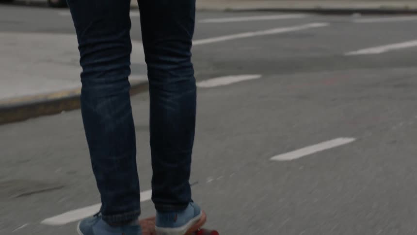A man skateboards down a city street