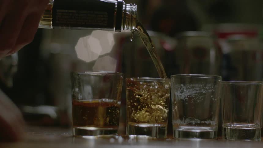 Person filling up shot glasses