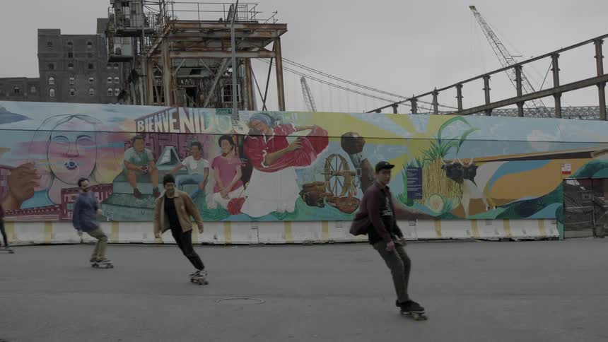 Several young adults skateboarding on a city street