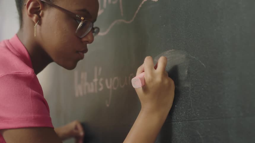 A girl is writing on the chalkboard