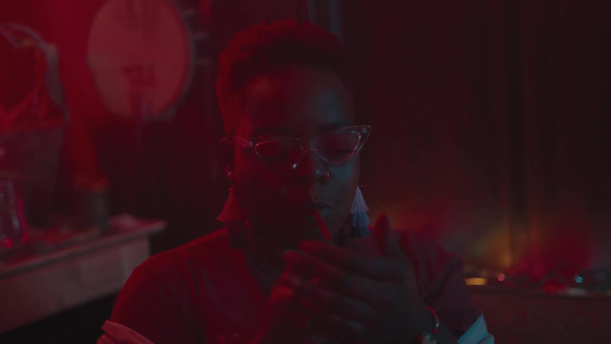 A woman lights a cigarette in a dim room