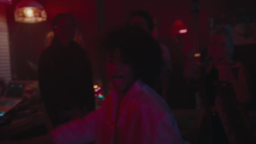 A woman is dancing in front of a crowd at a party