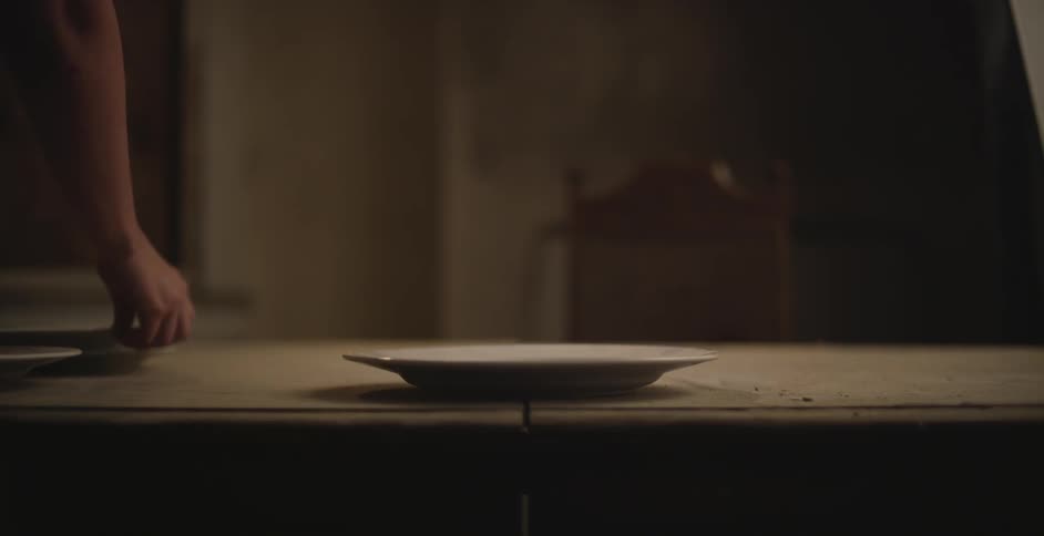 A person is stacking plates on a table