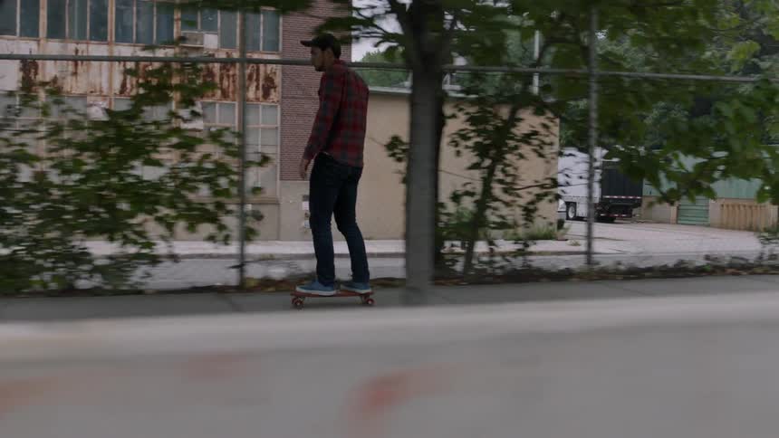 Person riding a skateboard on a city sidewalk