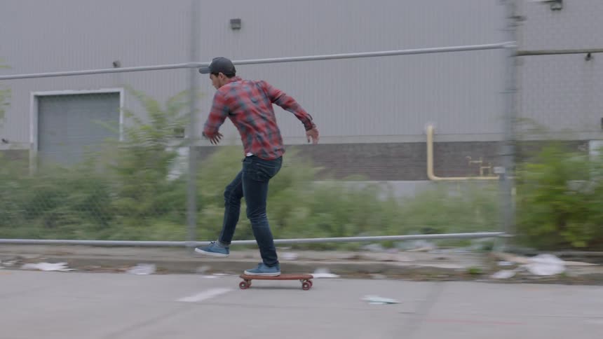A man is skateboarding down a sidewalk