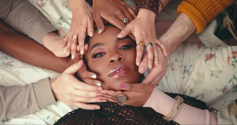 A group of people are massaging a womans face