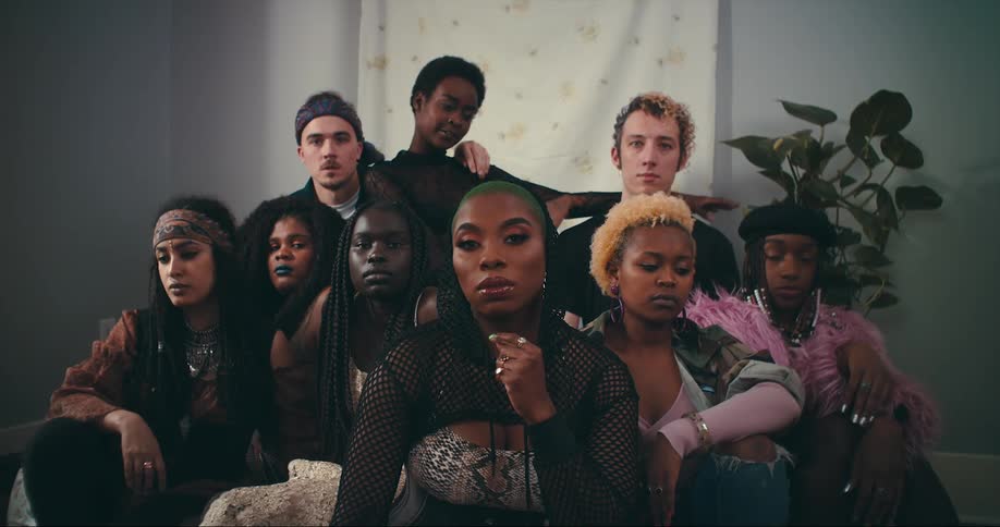 A diverse group of friends sitting in a group looking straight ahead for a photo