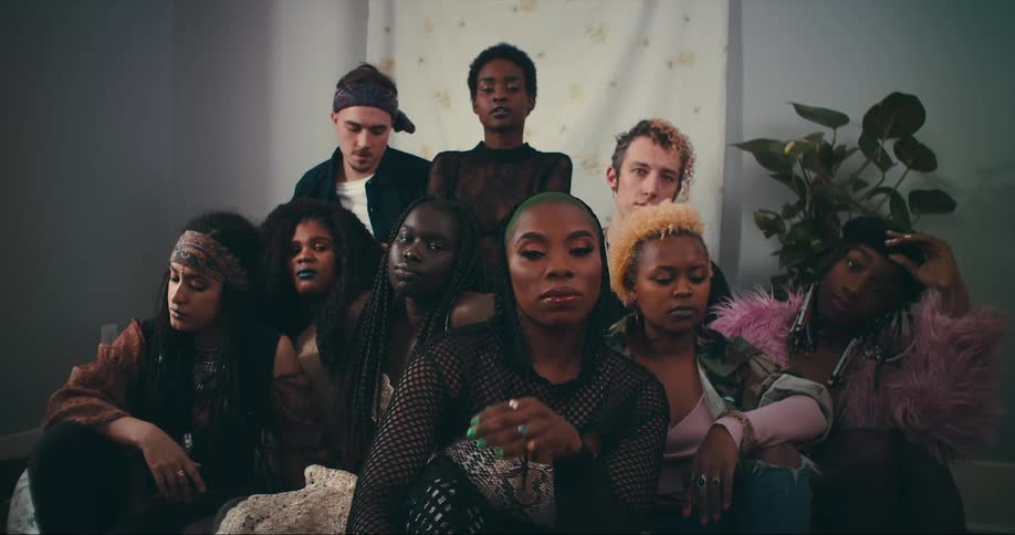 A group of friends pose in front of a hanging tapestry on the wall
