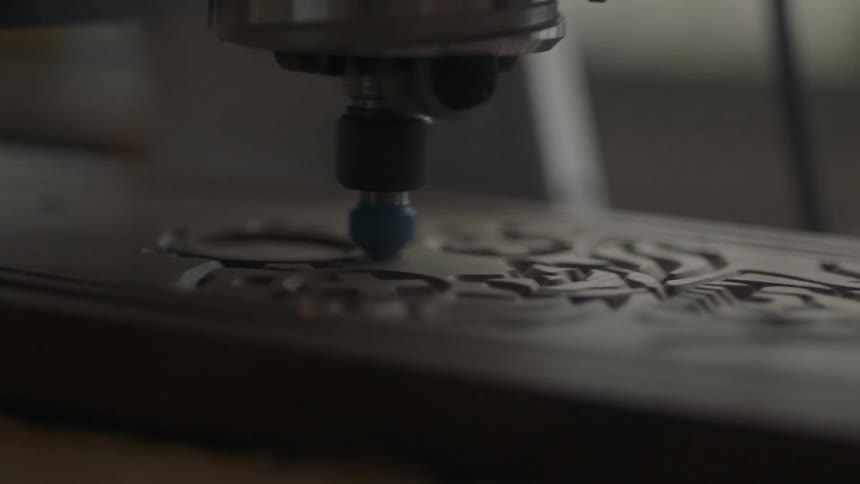 A tool is used to carve a design in a piece of wood