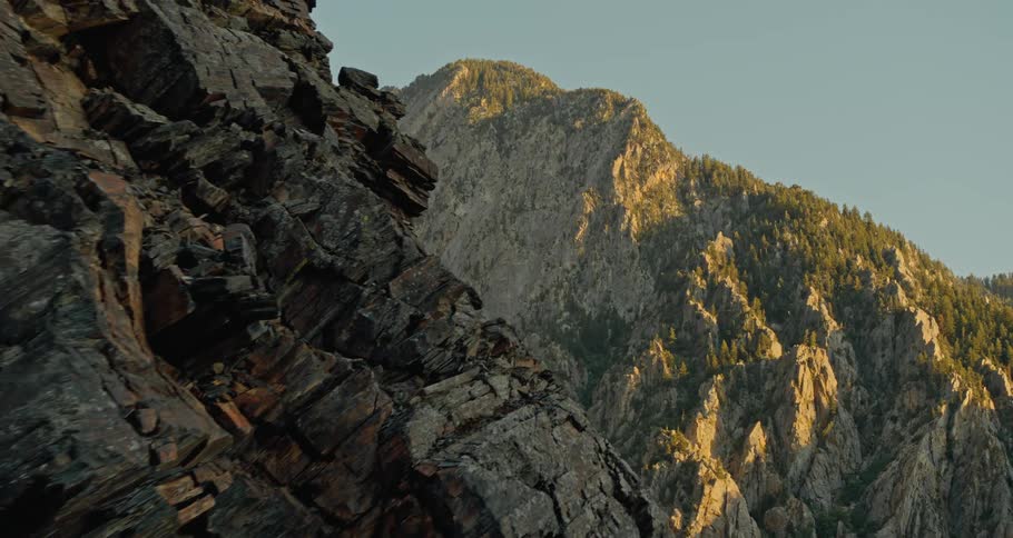 Sun shines on one side of forest covered mountains leaving the other in shadow