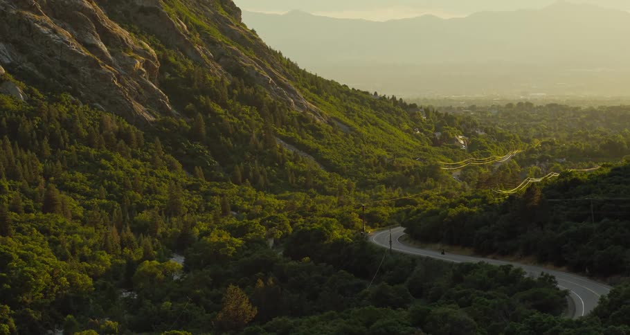 A motorcycle rides on the road by the mountain