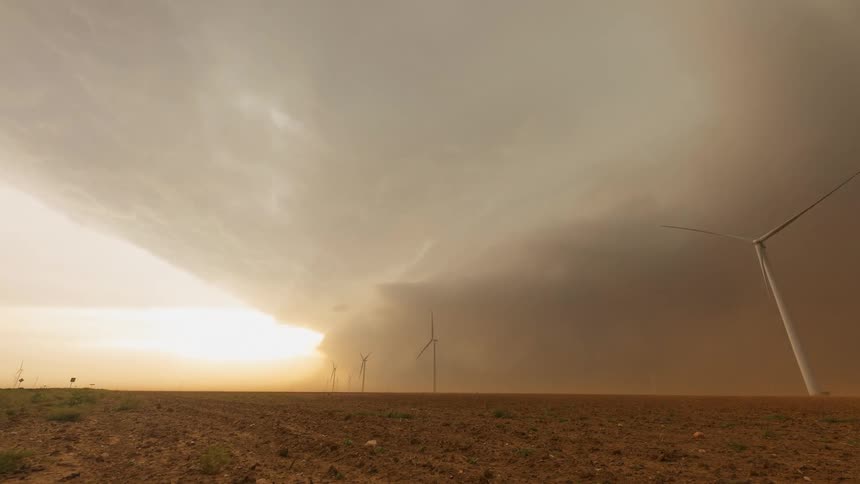 Storm clouds gather and rain down on wind turbines