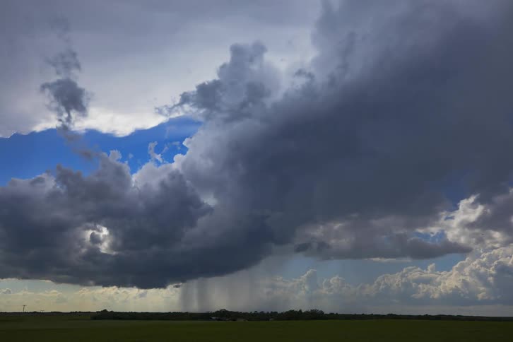 Bright white cumulus clouds are overhead and dark clouds move in and bring a storm