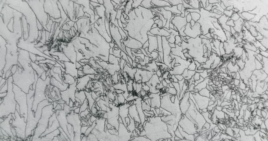 Green tinted crevices meander and criss cross across white surface