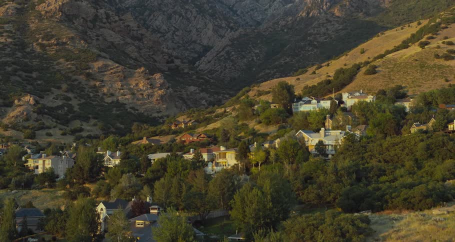 Luxury homes sit among trees at base of slope in mountains