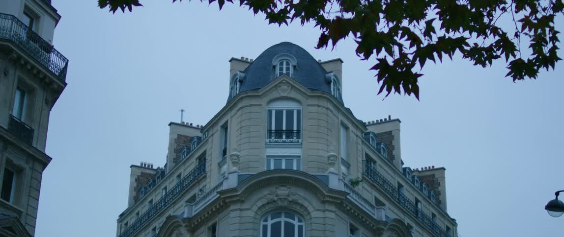 The facade of a large building on a corner in a metropolis during the day
