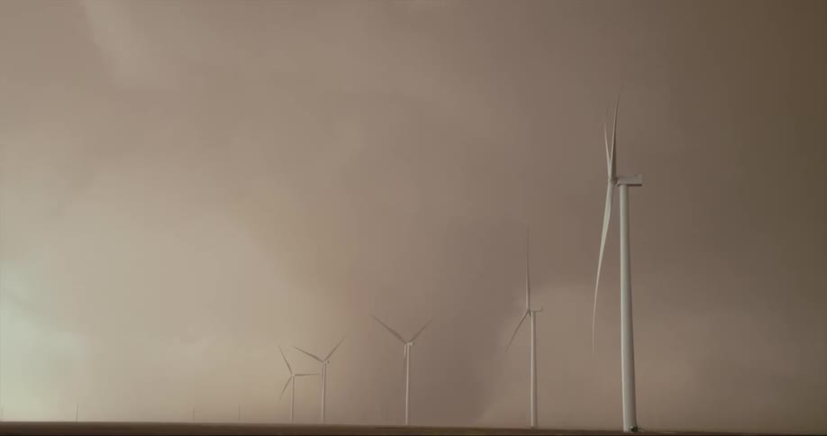 Wind mills are shown in a grassy landscape
