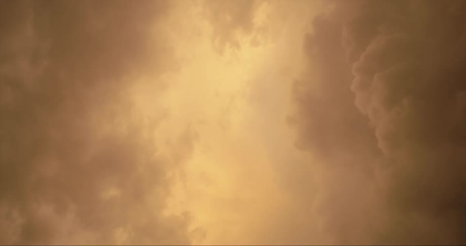 Darker storm clouds obscure sun as lightning strikes are visible toward brighter center of clouds