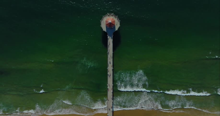 People hang out on a boardwalk over the water