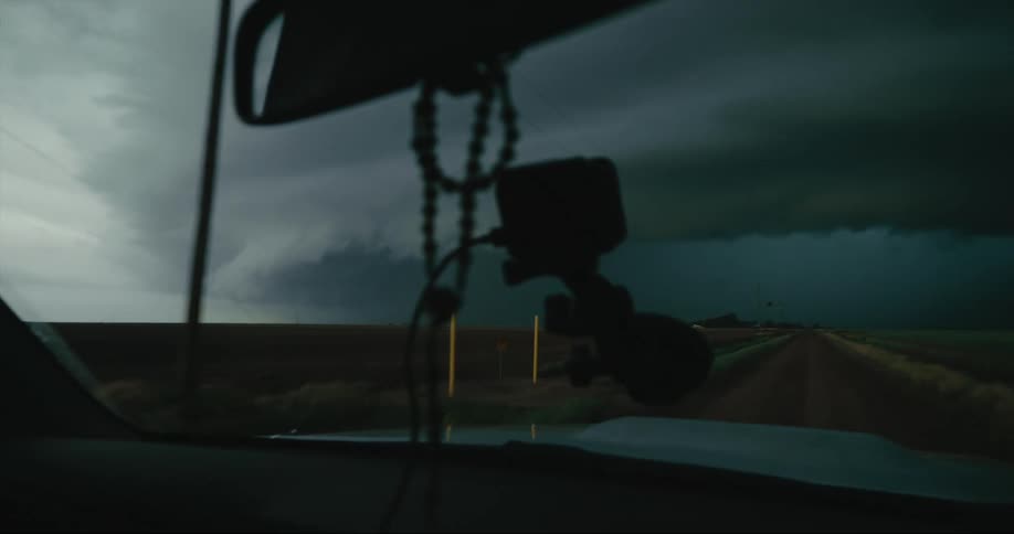 The vehicle is traveling towards the heavy storm clouds