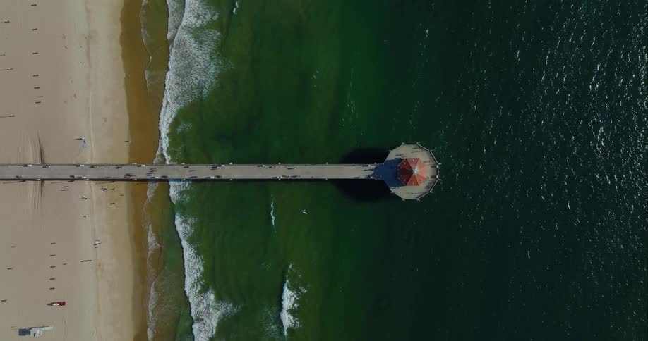 A long boardwalk on the beach leads to a gazebo on the water