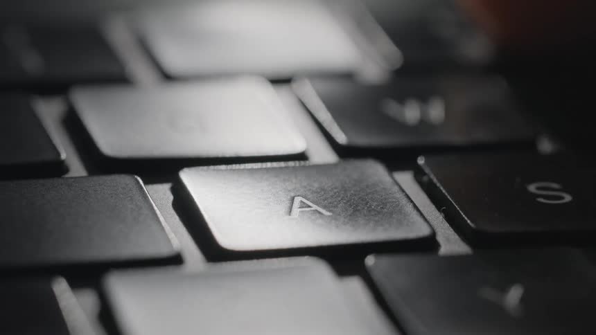 A person presses the a button on a keyboard