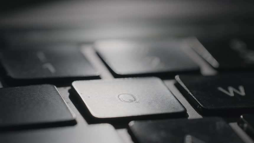 Person pushes the letter q key on computer keyboard