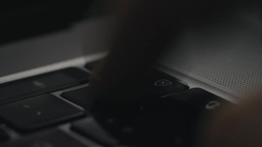 A person presses the backspace key on a laptop