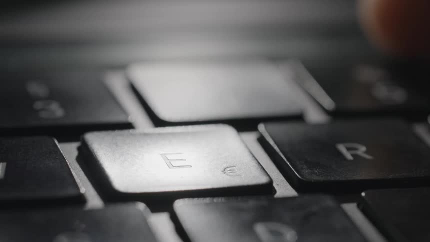 Persons finger touches keyboard letter