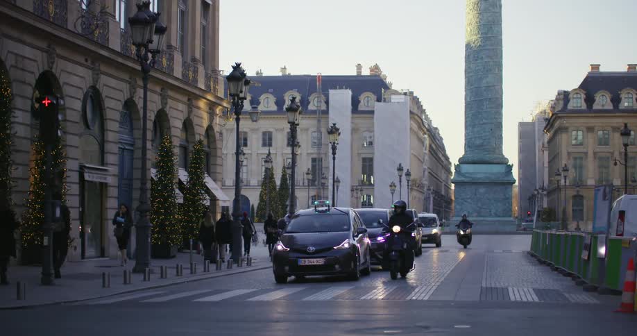 Cars and motorcycles stop at a traffic light as a bicycle makes a turn
