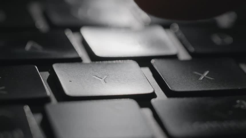 Finger pushes a keyboard button with the letter y on it