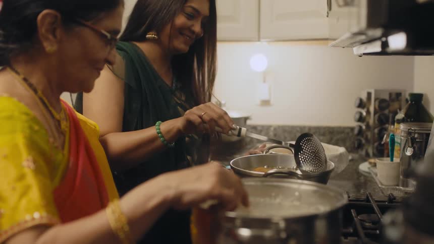 A woman cooks with her mother in the kitchen