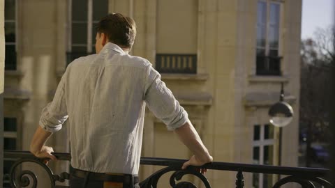 Man standing at a railing of a balcony