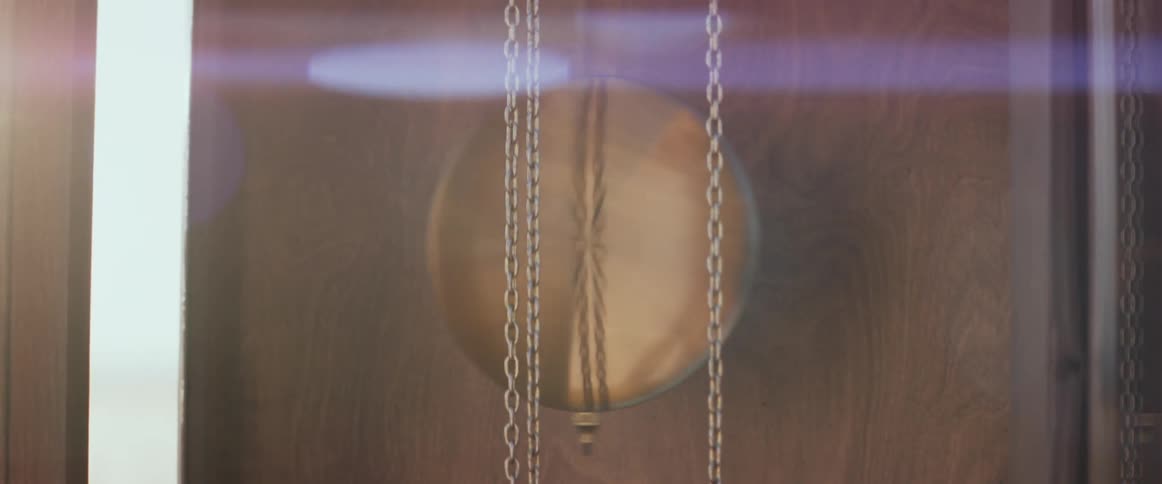 Man sets pendulum of grandfather clock to swaying