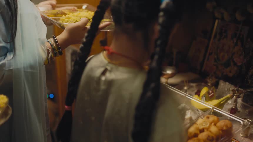 People stand in line with pates of food at a restaurant
