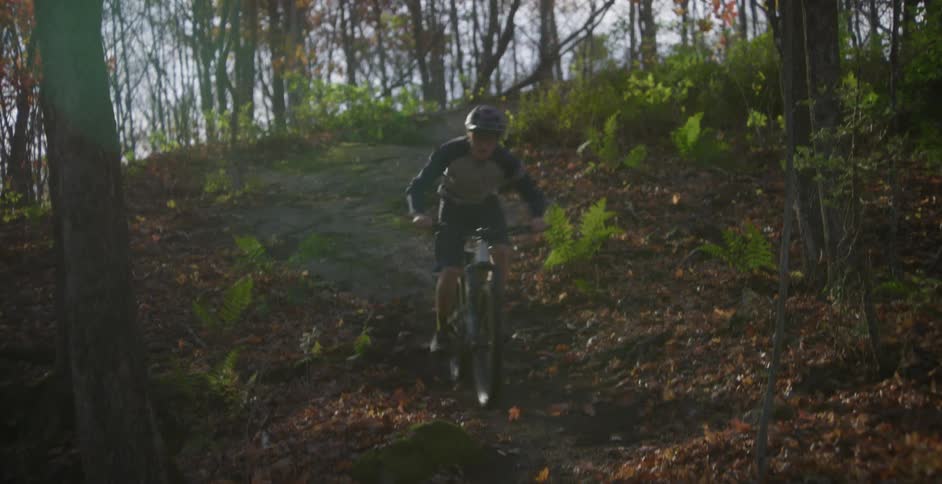 A mountain biker riding down a hill in a forest
