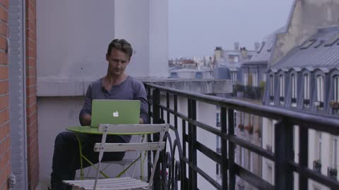 Person using a laptop while sitting on a terrace