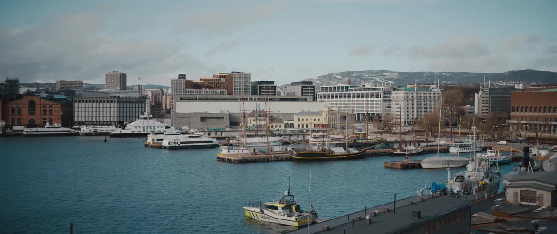 View of the Oslo city skyline with boats and ships docked at Aker Brygge Marina in Pipervika Bay, Oslo, Norway