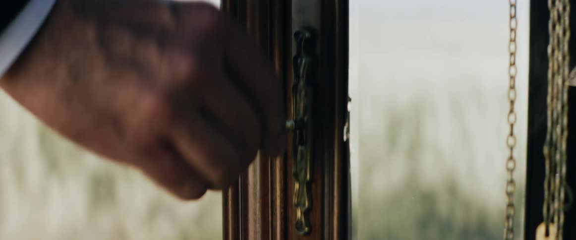 A person unlocking and opening the door of a grandfather clock