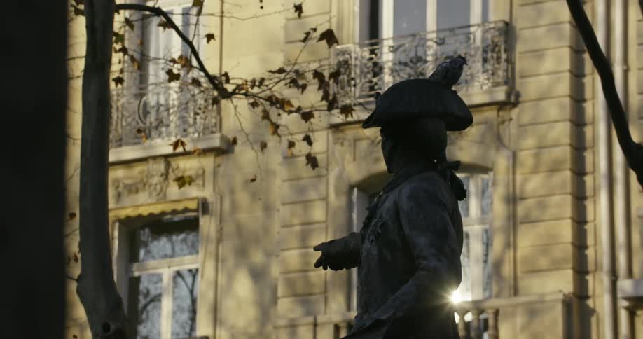 Birds are on a statue one flies off it's hand