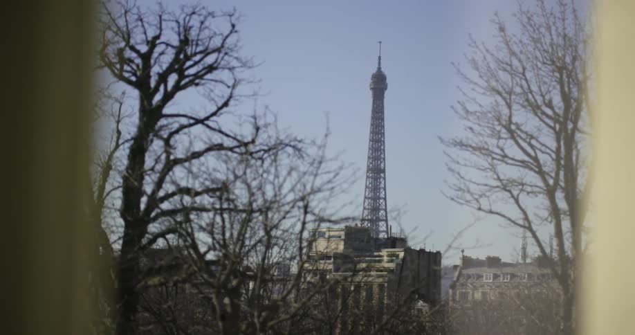 View out a window of a tower in the distance