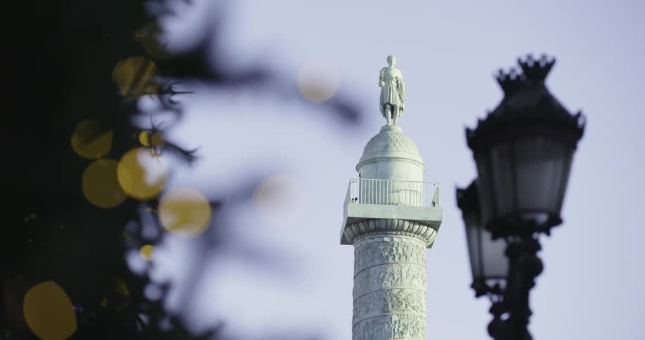 Statue standing on a tall tower against a clear blue sky