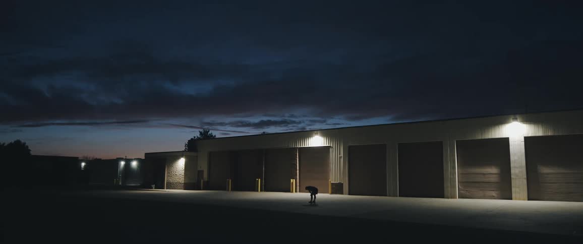 A person bends over in front of a storage units