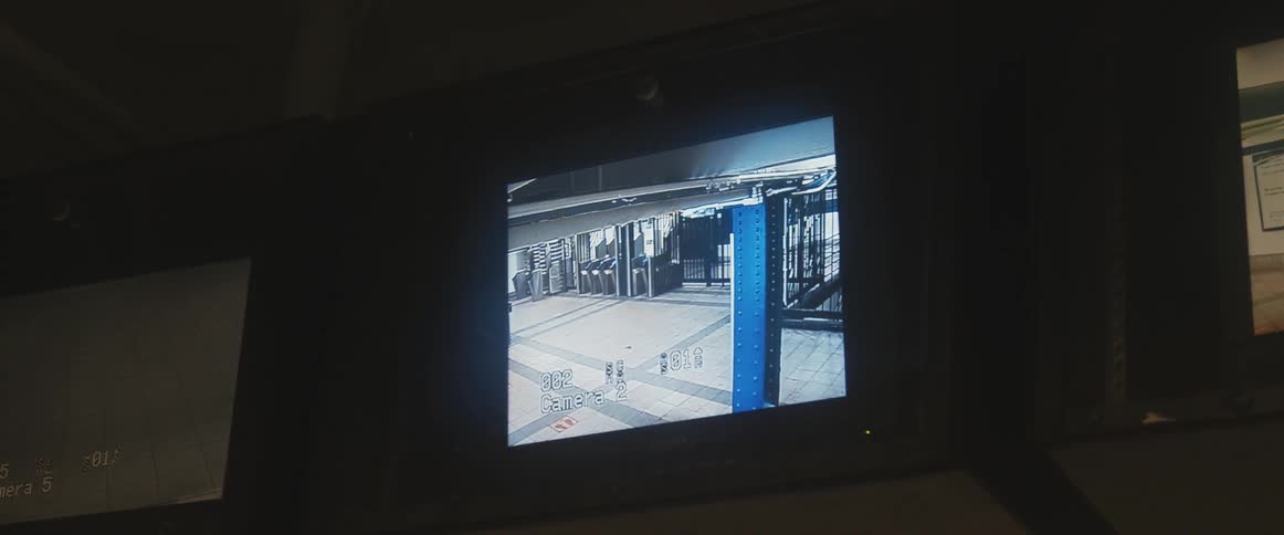A monitor displays surveillance footage of the inside of a building