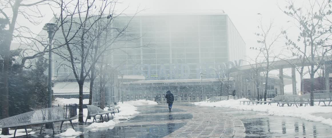 A person walks towards an office building during a snow storm
