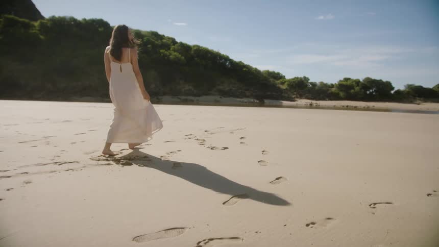 A woman is walking on the beach