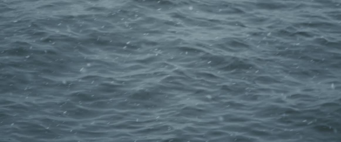 Snow falling over waves in the ocean