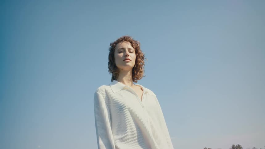 A woman stands in a grassy field
