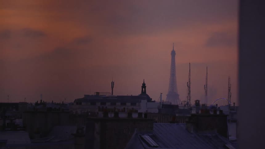 The sun sets over buildings in Paris