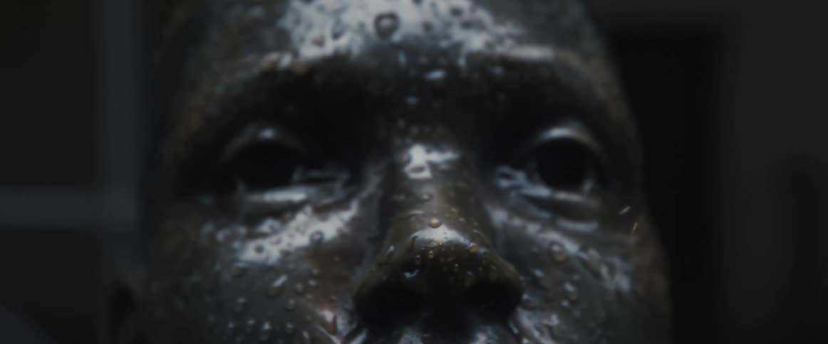 A mans face is covered in water drops and there are no eyes